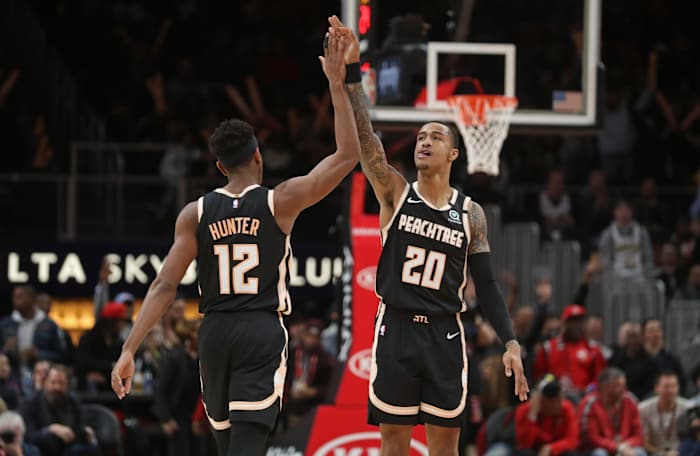 Jan 22, 2020; Atlanta, Georgia, USA; Atlanta Hawks forward De'Andre Hunter (12) celebrates a three-point basket with forward John Collins (20) in the fourth quarter against the LA Clippers at State Farm Arena.